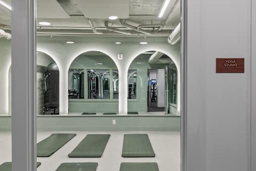 A yoga studio with green mats and mirrors on the wall at The Carousel Apartments, Richmond, 23220