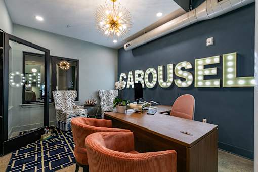 A room with a desk, chairs, and a sign at The Carousel Apartments, Richmond, Virginia