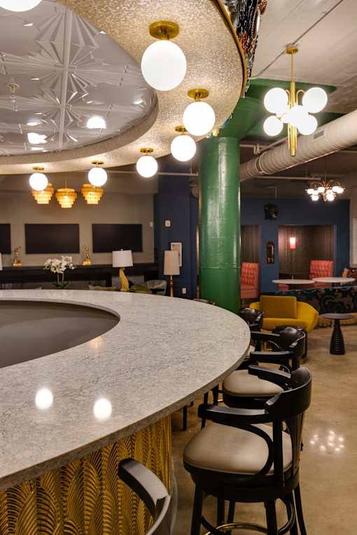A bar with a curved counter and stools at The Carousel Apartments, Richmond, VA, 23220