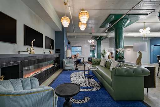 A living room with a fireplace and a blue rug at The Carousel Apartments, Virginia, 23220