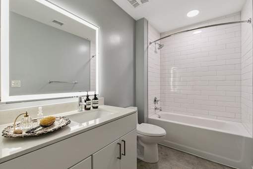 A white bathroom with a toilet, sink, and bathtub at The Carousel Apartments, Richmond, Virginia