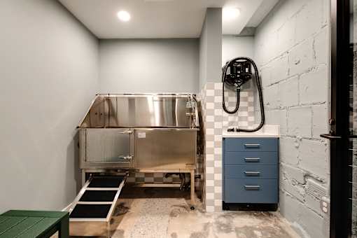 A stainless steel sink is installed in a bathroom with a blue cabinet and a green table at The Carousel Apartments, Richmond, Virginia