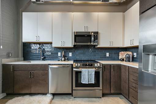 A modern kitchen with stainless steel appliances and white cabinets at The Carousel Apartments, Richmond, Virginia