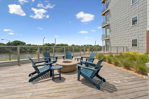 A wooden deck with blue chairs and a table  at The Waterford At Rocketts Landing Apartments, PRG Real Estate, Richmond, Virginia
