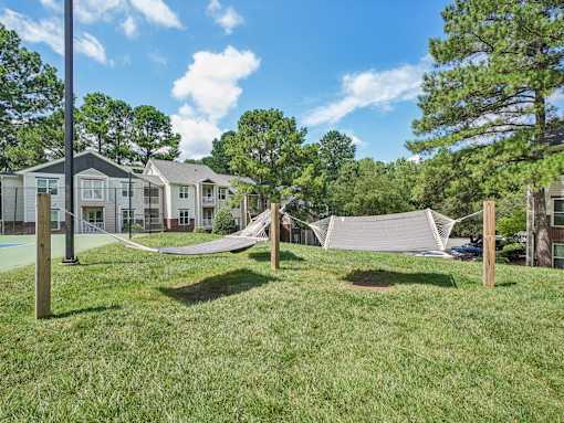 A residential area with houses and a hammock at The Falls Apartments in Raleigh NC