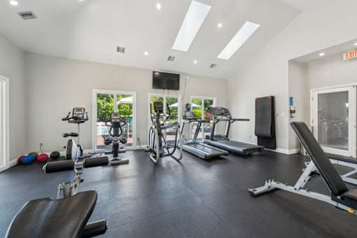 A spacious gym with a variety of equipment including treadmills, exercise bikes, and weight machines. at The Timbers Apartments, Richmond, Virginia