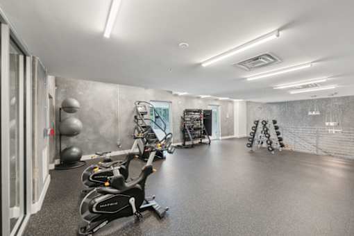 A gym with exercise equipment and a mirror on the wall at South Falls Tower Apartments, Richmond