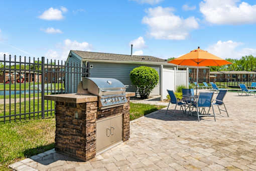 A patio with a grill and chairs is set up at Rivers Landing Apartments, Hampton, VA