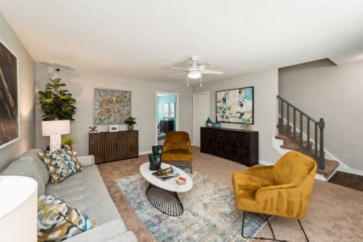 a living room with couches and chairs and a staircase at Hyde Park Townhomes, PRG Real Estate Management, Chester, VA