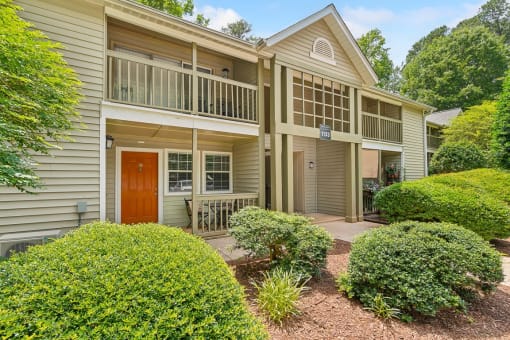 the front of a house with a porch and a red door at Clarion Crossing Apartments, PRG Real Estate Management, Raleigh