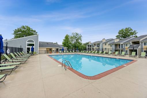 A large outdoor swimming pool surrounded by sun loungers and a building in the background at Chinoe Creek Apartments, Kentucky