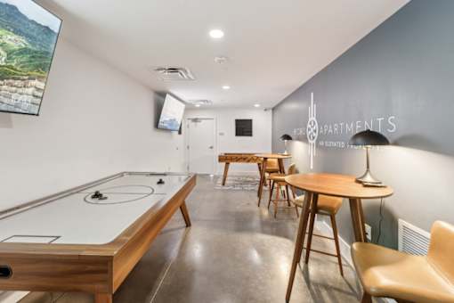 A room with a pool table and a TV mounted on the wall.