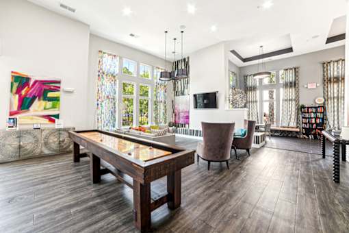 A modern living room with a wooden floor and a glass table at Proximity Apartments, South Carolina, 29414