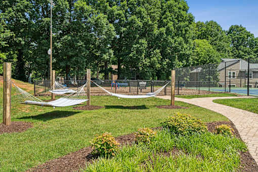 A playground with a swing set and a basketball court at Woodcreek Apartments, Cary, NC, 27511