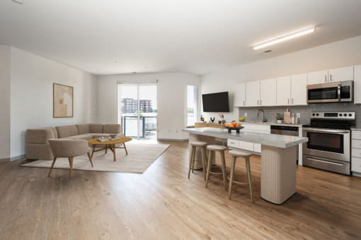 a living room with a kitchen and an island with chairs and a table at The Waterford At Rocketts Landing Apartments, PRG Real Estate, Richmond, Virginia
