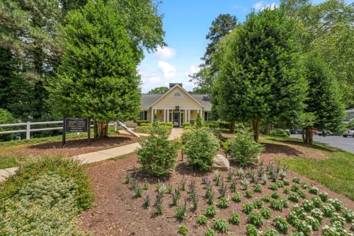a garden in front of a house with a sign at Clarion Crossing Apartments, PRG Real Estate Management, Raleigh