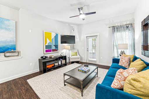 A living room with a blue couch and a coffee table at Proximity Apartments, South Carolina, 29414