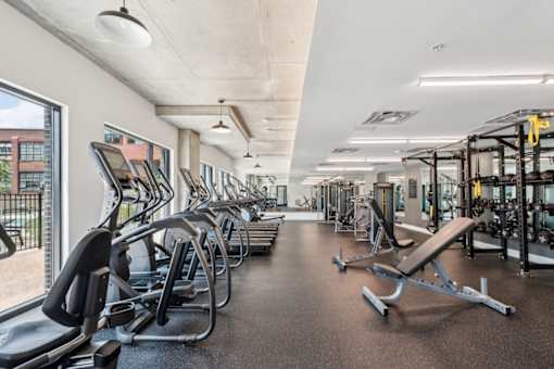 A gym with treadmills, weights, and exercise equipment.