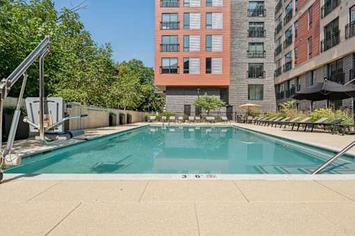 A swimming pool surrounded by buildings and trees.