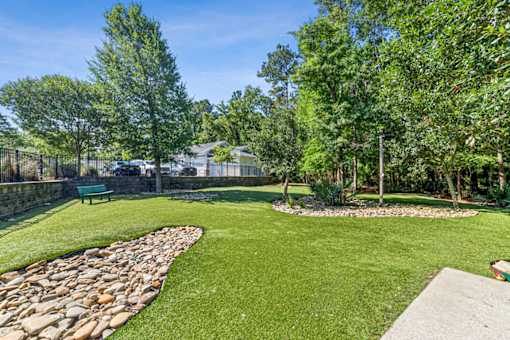 A green lawn with a stone pathway and a bench at Proximity Apartments, South Carolina, 29414