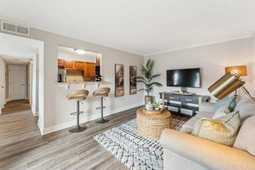 A living room with a couch, a chair, a table, and a television.