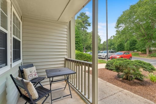 a patio with two chairs and a table on a porch at Clarion Crossing Apartments, PRG Real Estate Management, Raleigh