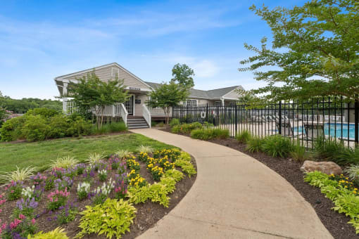 a sidewalk in front of a house with a pool at Hyde Park Townhomes, PRG Real Estate Management, Chester, VA