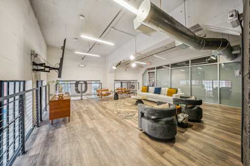 A modern office space with wooden floors and furniture. at The Locks, Richmond, VA, 23219