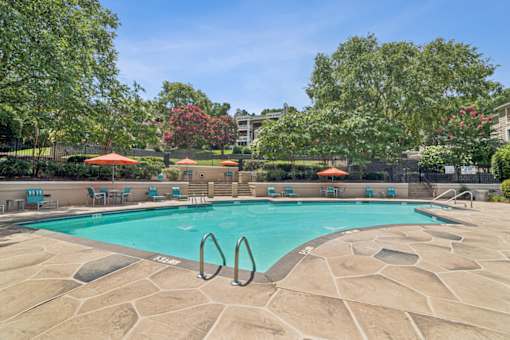 A swimming pool surrounded by trees and chairs at Beacon Ridge Apartments, PRG Real Estate Management, Greenville, 29615