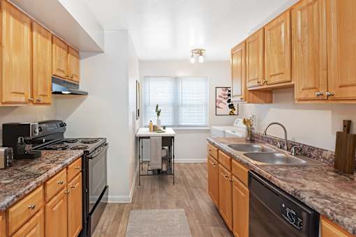 A kitchen with wooden cabinets and granite countertops at Rivers Landing Apartments, Hampton 23666