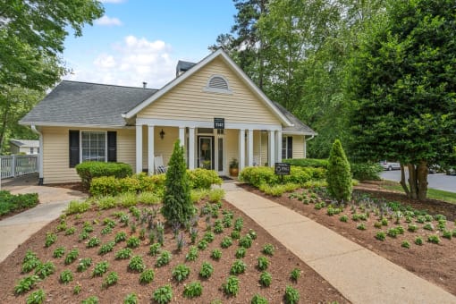 a home with a garden and a sidewalk in front of it at Clarion Crossing Apartments, PRG Real Estate Management, Raleigh