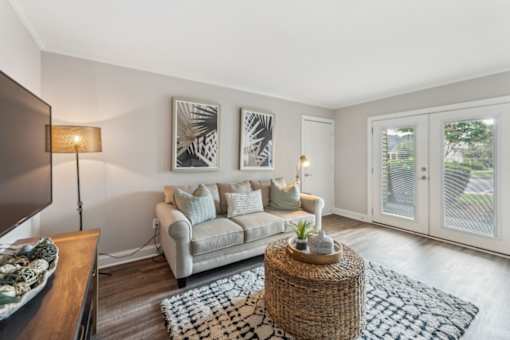 A living room with a grey couch and a woven coffee table.