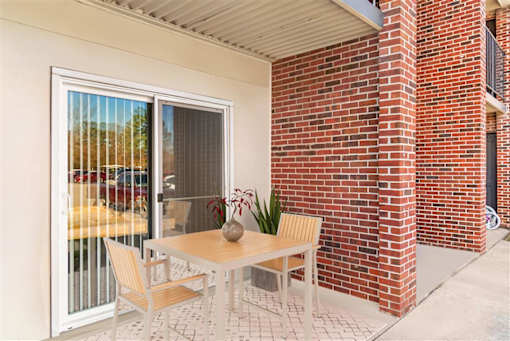 A patio with a table and chairs is shown at Rivers Landing Apartments, Virginia
