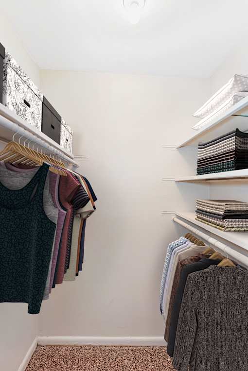 A white shelf with a stack of books on it at Rivers Landing Apartments, Hampton
