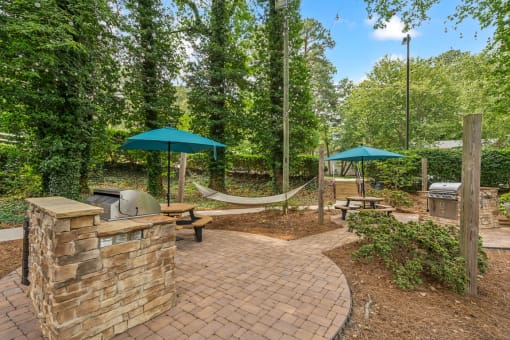 a brick patio with hammocks and umbrellas at Clarion Crossing Apartments, PRG Real Estate Management, Raleigh