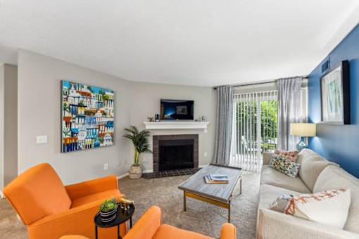 A living room with a fireplace, a painting on the wall, and a television at Chinoe Creek Apartments, Kentucky