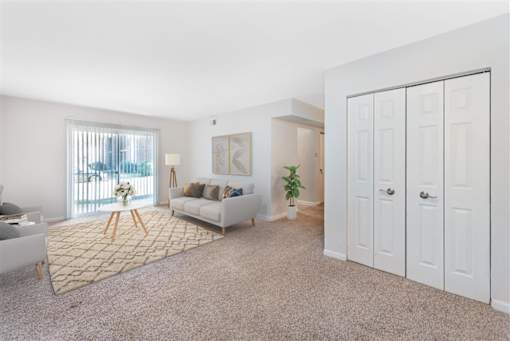 A living room with a couch, a rug, and a plant at Rivers Landing Apartments, Hampton, VA, 23666