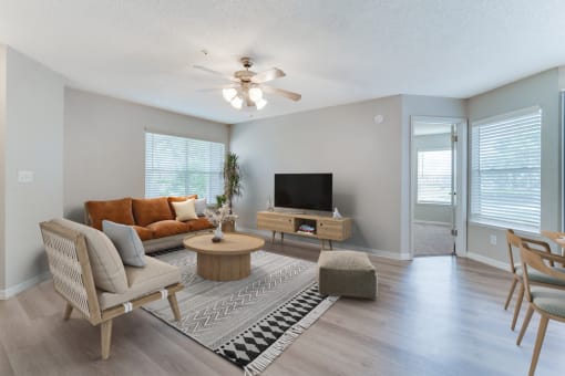 a living room with gray walls and a ceiling fan at Palm Crossing Apartments in Winter Garden, FL