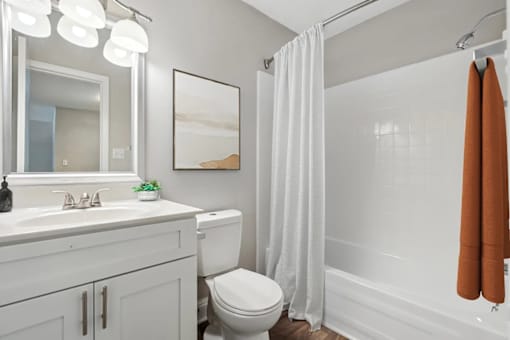 A bathroom with a toilet, sink, and shower at Clarion Crossing Apartments, PRG Real Estate Management, Raleigh