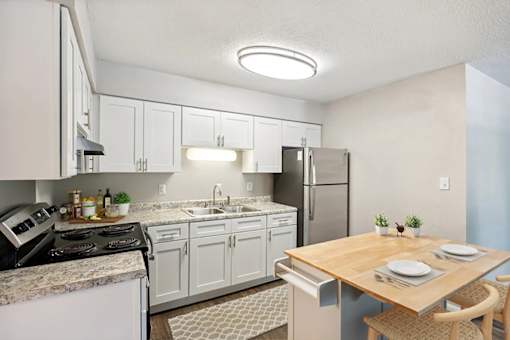 A kitchen with a table set for two at Clarion Crossing Apartments, PRG Real Estate Management, Raleigh