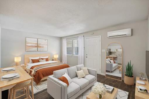 A well-lit bedroom with a bed, couch, and a dining table at Clarion Crossing Apartments, PRG Real Estate Management, Raleigh