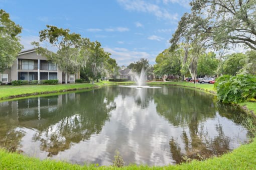A pond with a fountain at Palm Crossing Apartments in Winter Garden, FL