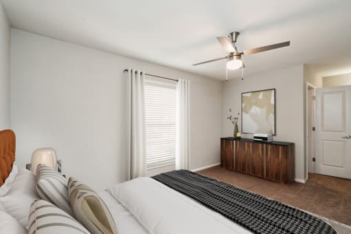 a bedroom with a large bed and a ceiling fan  at Lake Johnson Mews, Raleigh, 27606