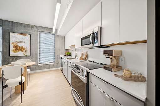 A modern kitchen with white cabinets and stainless steel appliances. at The Locks Tower, Richmond, VA, 23219