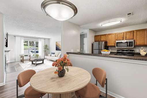 A kitchen with a table and chairs in the foreground and a living room in the background at Park Ridge Estates, Durham, 27713