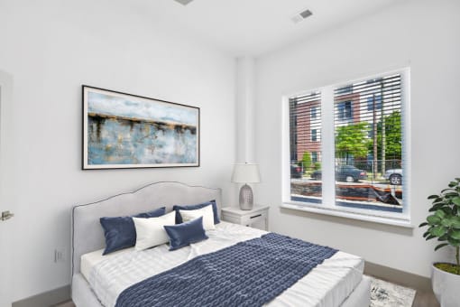 a bedroom with a large bed and two windows at The Point Apartments on 38th, Norfolk, VA