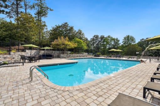 a resort style swimming pool with lounge chairs and umbrellas  at Park Ridge Estates, Durham