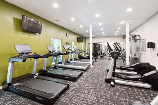 a gym with cardio equipment and a flat screen tv  at Park Ridge Estates, North Carolina, 27713