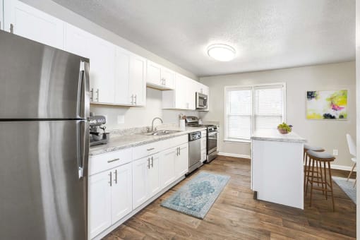 Open concept kitchen with quartz countertops and island seating at Hyde Park Townhomes, PRG Real Estate Management, Chester, 23831