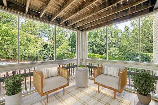 A wooden balcony with two chairs and a table at Beacon Ridge Apartments, PRG Real Estate Management, Greenville, 29615